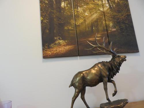 a bronze reindeer on a table in front of a painting at Bankhouse B&B in Aberlour