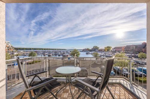 a balcony with a table and chairs and a view of a harbor at Ferienwohnung Hafenglück- Ideal für Familien mit Balkon und Yachthafenblick in Waren