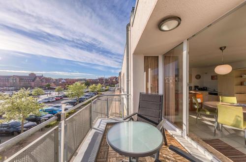 a balcony with a glass table and a view of a city at Ferienwohnung Hafenglück- Ideal für Familien mit Balkon und Yachthafenblick in Waren
