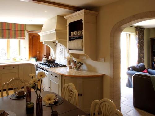 a kitchen with a table and a stove top oven at Oundle Bespoke Apartments in Oundle