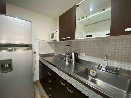 a kitchen with a sink and a refrigerator at Apartamento en Envigado al Sur de Medellin in Envigado