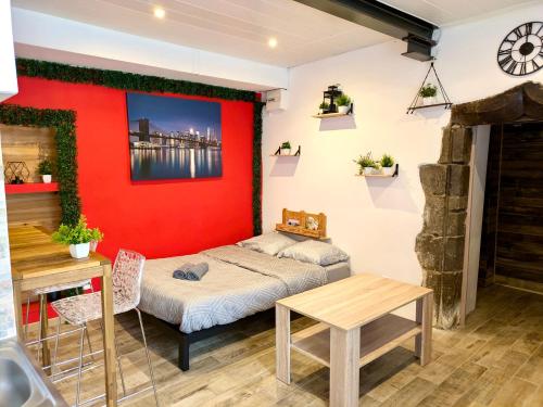 ein Schlafzimmer mit einem Bett und einer roten Wand in der Unterkunft Charme entre plage et montagne in Sciez