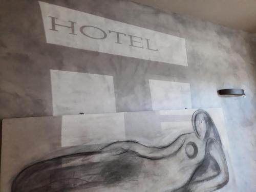a painting of a whale on a wall with a hotel sign at Art Hotel Pietrasanta in Pietrasanta