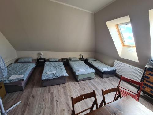 a room with three beds and a table and a window at W20 Hostel in Golędzinów