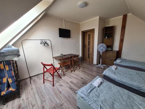 a room with a bed and a table with a desk at W20 Hostel in Golędzinów