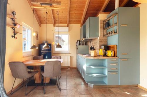 a kitchen with a wooden table and a dining room at Blau am See -Ihr Ferienhaus am Jabelschen See in Jabel