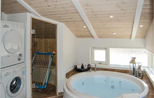 a bathroom with a tub and a washing machine at Holiday Home Hægvej Grenaa V in Grenå