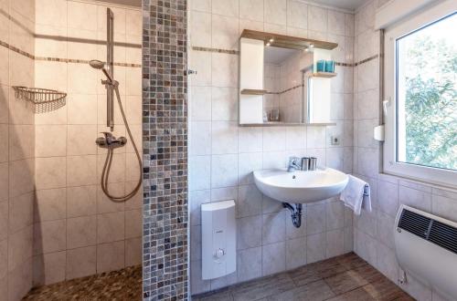 a bathroom with a sink and a shower at MöwenKieker mit Terrasse im Ferienpark Silz in Silz