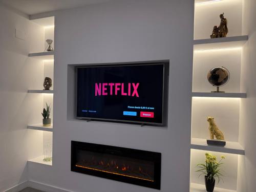 a television on a wall with a fireplace at Luis Montoto in Seville