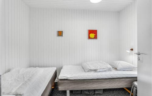 two beds in a room with white walls at Amazing Home In Rømø With Kitchen in Havneby