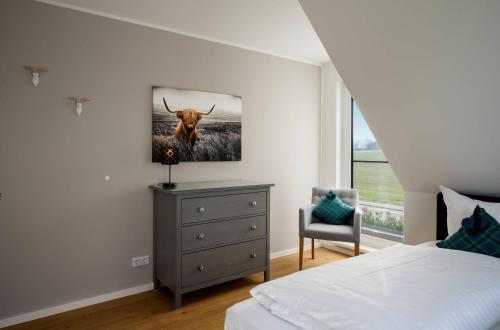 a bedroom with a bed and a picture of a cow on the wall at Duncan House mit Kamin und Garten in Göhren-Lebbin