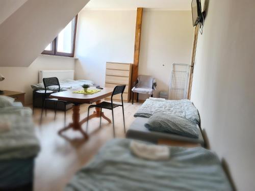 a room with two beds and a table and chairs at W20 Hostel in Golędzinów