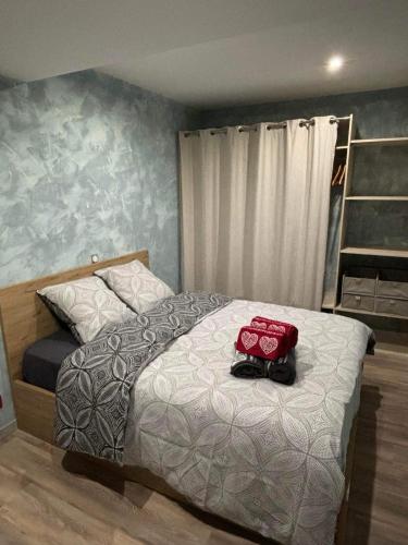 - une chambre avec un lit doté d'un sac rouge dans l'établissement Le Petit Ardennais, à Charleville-Mézières