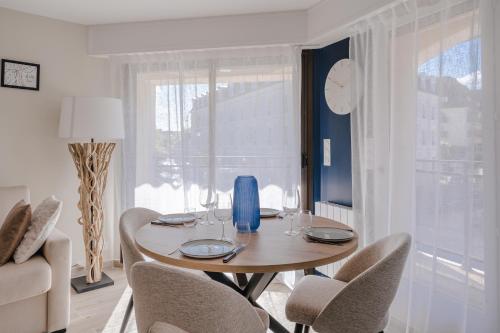 a dining room with a table and chairs and a window at Central appartement with terrace and free parking in Deauville