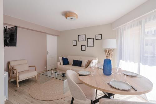 a living room with a table and a couch at Central appartement with terrace and free parking in Deauville
