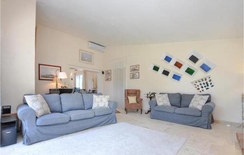 - un salon avec deux canapés bleus et une chaise dans l'établissement 4 Bedroom Amazing Home In Fréjus, à Fréjus