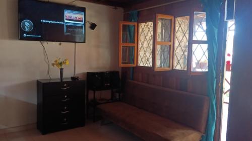 a room with a couch and a tv and windows at Chalet Completo para Familias Condominio Campestre Privado con Piscinas, wifi, AC in Santa Marta