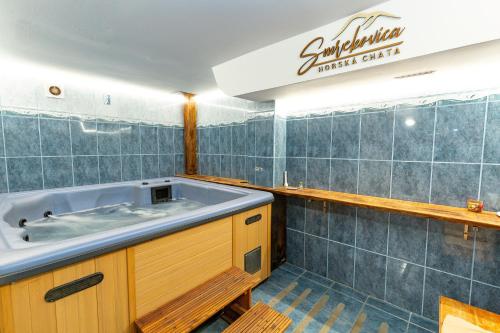a bath tub in a bathroom with blue tiles at Horská chata Smrekovica in ľubochňa