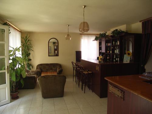 a living room with a bar and a kitchen with chairs at Carmen Pension in Budapest