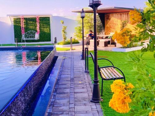 a bench next to a swimming pool next to a house at شالية ڤولانس - Volans Chalet VIP in Kirshah