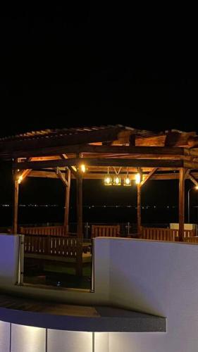 a wooden deck with lights on it at night at شالية ڤولانس - Volans Chalet VIP in Kirshah