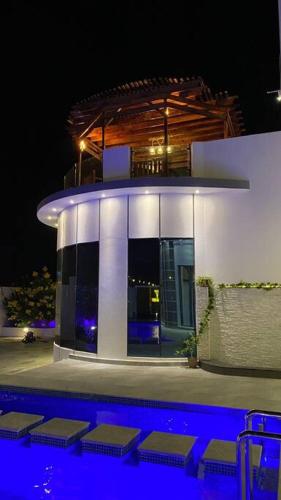 a building with a pool in front of it at night at شالية ڤولانس - Volans Chalet VIP in Kirshah