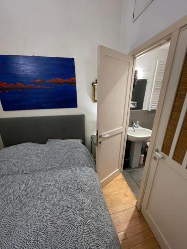 une chambre avec un lit et une salle de bain avec un lavabo dans l'établissement Romantique Suite Pont Neuf, à Paris