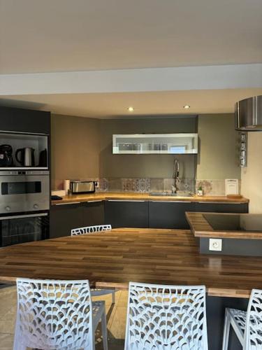 une cuisine avec une grande table et des chaises en bois dans l'établissement L appart, à Brest