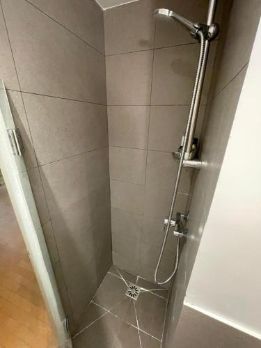 une douche dans une salle de bain avec une porte vitrée dans l'établissement Romantique Suite Pont Neuf, à Paris