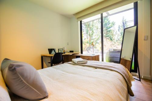 a bedroom with a bed and a large window at Arezzo Forest View in Quito