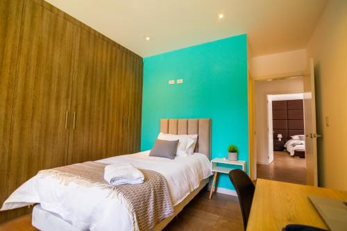 a bedroom with a large bed with a green wall at Arezzo Forest View in Quito