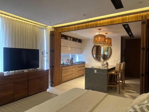 a bedroom with a television and a kitchen with a table at Mako 54 in Puerto Vallarta