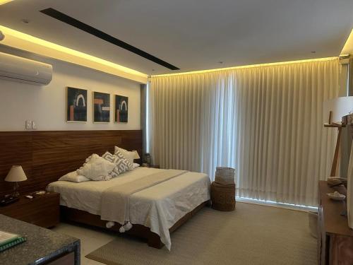 a bedroom with a bed and a large window at Mako 54 in Puerto Vallarta