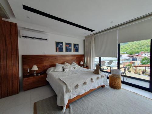 a bedroom with a large bed and a large window at Mako 54 in Puerto Vallarta