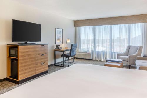 a hotel room with a bed and a flat screen tv at Drury Inn & Suites St. Louis-Southwest in Peerless Park
