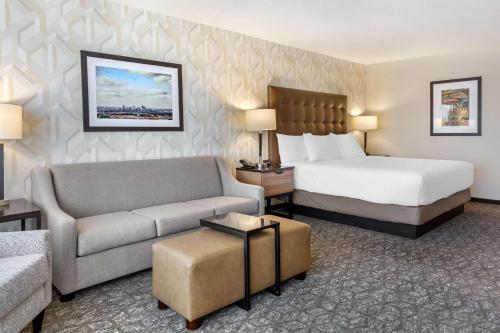 a hotel room with a bed and a couch at Drury Inn & Suites St. Louis-Southwest in Peerless Park