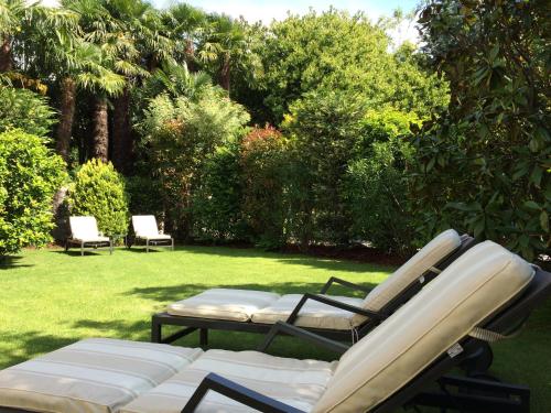 two chairs and a couch on a lawn at Villa Palmira Kinderfreies Hotel in Cannobio