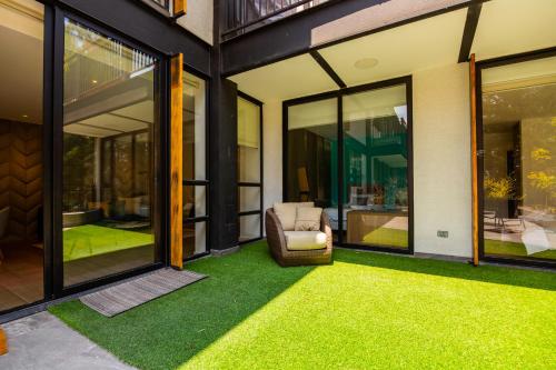a patio with a chair and some grass at Arezzo Forest View in Quito