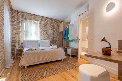 a bedroom with a bed and a brick wall at Vailato Swan White Suite in Corfu
