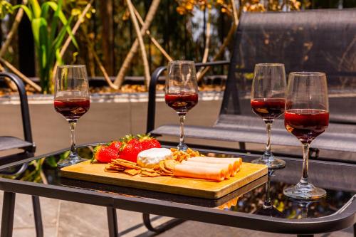a table with two glasses of wine and a plate of food at Arezzo Forest View in Quito