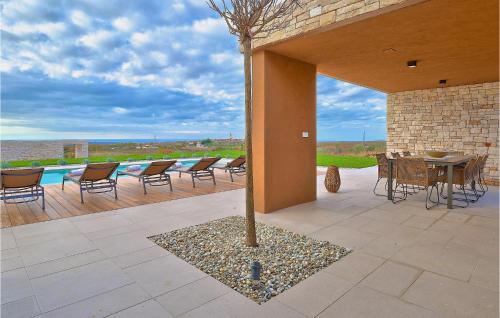 a patio with a tree and a table and chairs at Villa Vigneto in Brtonigla