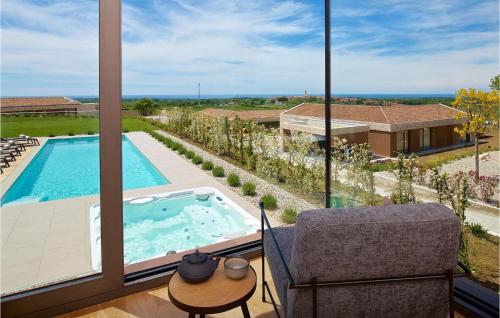 a room with a view of a swimming pool and a chair at Villa Vigneto in Brtonigla