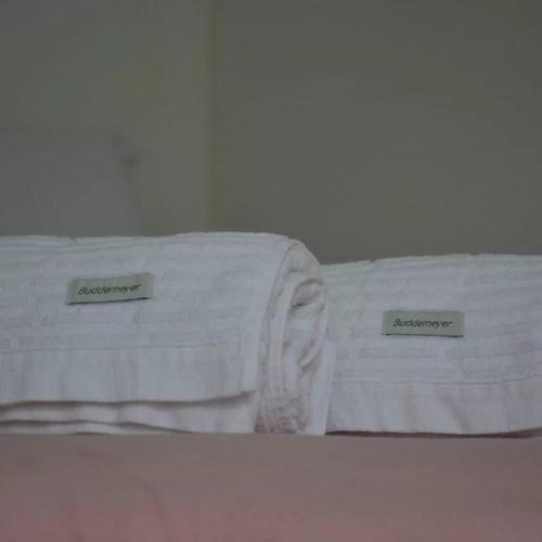 two white towels sitting on top of a bed at POUSADA CANTINHO DA Beth in Caravellas