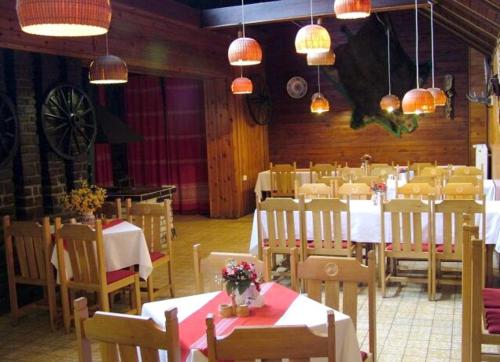 Un comedor con mesas, sillas y luces. en Bungalovy Tatranec, en Tatranská Lomnica