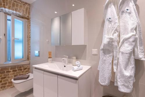 a white bathroom with a sink and a toilet at Vailato Swan White Suite in Corfu