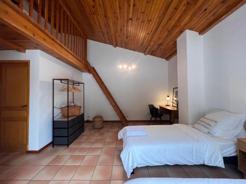 une chambre avec deux lits et un plafond en bois dans l'établissement Douce Provence, à Saint-Paul-en-Forêt