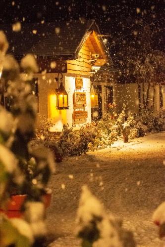 a house covered in snow at night at Hosteria El Condado in San Carlos de Bariloche