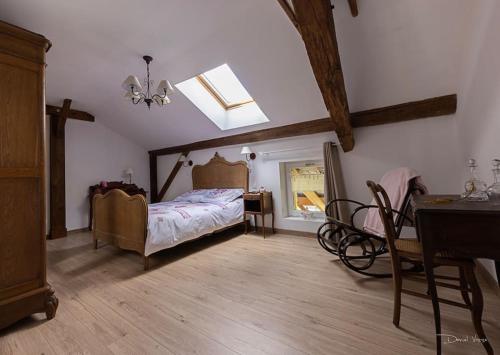 une chambre avec un lit et une lucarne dans l'établissement Aux draps de foin, à Bellefontaine