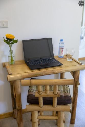 a laptop computer sitting on top of a wooden table at BOHO Boutique Bungalows in Baan Tai