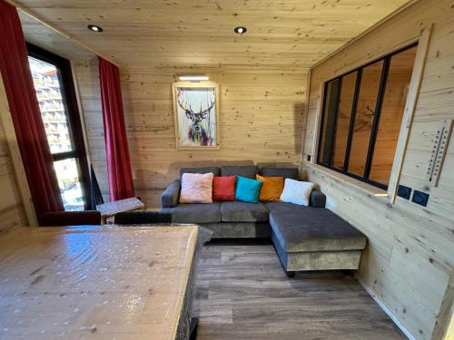 a living room with a couch in a cabin at Les appartements de Makalu Val Thorens in Val Thorens